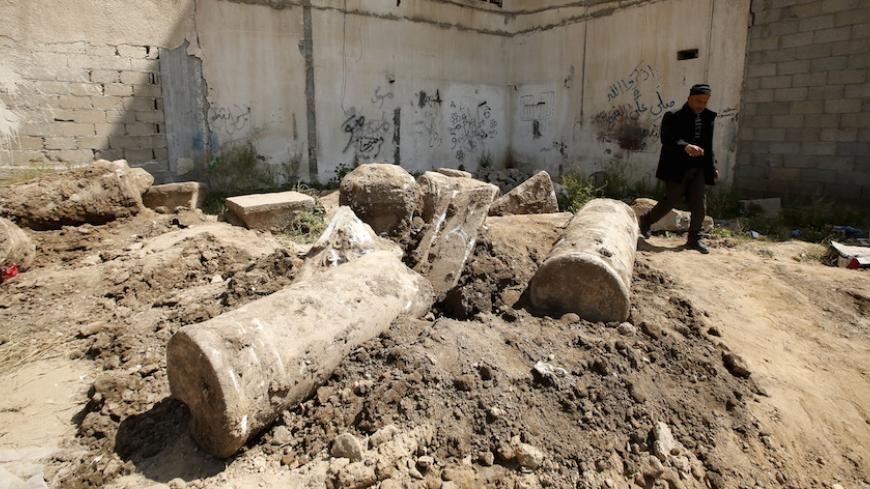A man walks past ancient ruins which archaeologists say may be part of a Byzantine church or cathedral dating from around 1,500 years ago, in Gaza City April 4, 2016. REUTERS/Mohammed Salem - RTSDHOZ