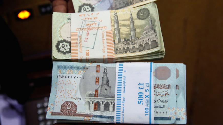 A bank employee counts stacks of Egyptian 5 pound and 50 piastre notes as he works at Bank Misr in downtown Cairo, Egypt, June 8, 2016. REUTERS/Amr Abdallah Dalsh - RTSGPW9