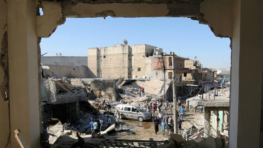 People inspect a site hit by airstrikes in the rebel held town of Atareb in Aleppo province, Syria, July 25, 2016. REUTERS/Ammar Abdullah  - RTSJHBF