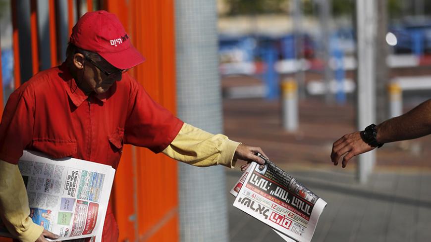 A man distributes the daily newspaper Israel Hayom at a train station in the southern city of Ashkelon, Israel November 19, 2015. Critics say Netanyahu, known as "Bibi," is hitting the wrong note when it comes to the media, weakening press freedom and holding sway over TV broadcasters in a country that bills itself as the Middle East's only true democracy. Since 2007, U.S. casino billionaire Sheldon Adelson, a major Netanyahu supporter, has published a free handout called Israel Hayom, Israel Today. It now
