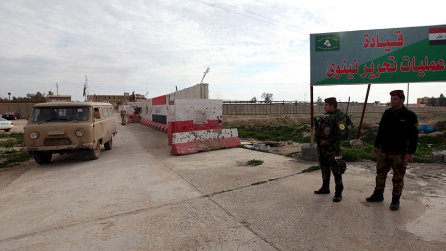 Iraqi army members stand guard at the entrance to the Nineveh Liberation Operations Command at Makhmour base, south of Mosul, Iraq February 14, 2016. REUTERS/Azad Lashkari - RTX26WPQ
