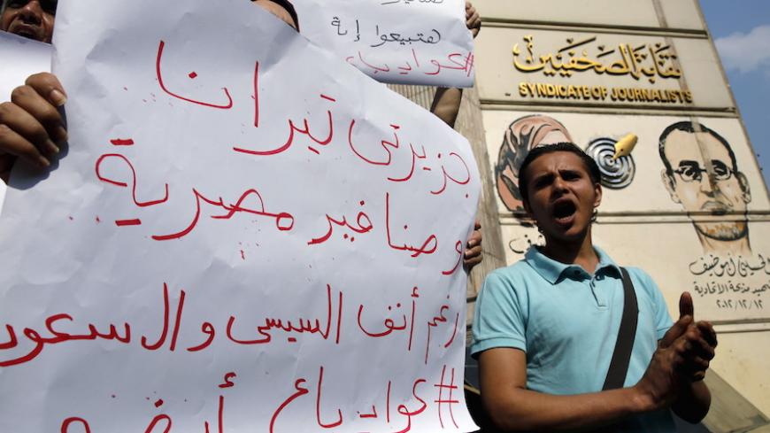 Egyptian activists shout anti-President Abdel Fattah al-Sisi and government slogans during a demonstration protesting against the government's decision to transfer two Red Sea islands to Saudi Arabia, in front of the Press Syndicate in Cairo, Egypt, April 13, 2016. The sign reads, "The two Islands Tiran and Sanafir are the Egyptians". REUTERS/Amr Abdallah Dalsh - RTX29RVO