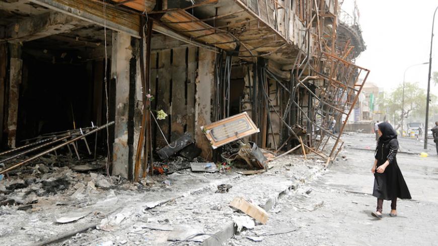A girl walks past the site after a suicide car bomb attack at the shopping area of Karrada, a largely Shi'ite district, in Baghdad, Iraq July 4, 2016. REUTERS/Ahmed Saad - RTX2JMRE