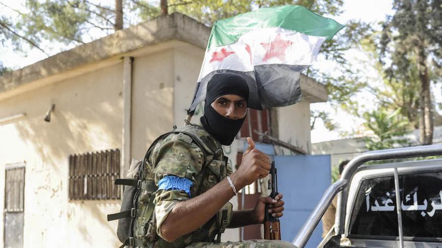 JARABLUS, SYRIA - AUGUST 31: A member of the Turkish-backed Free Syrian Army (FSA) gestures as he patrols in the border town of Jarablus, August 31, 2016, Syria. Turkish troops and Turkey-backed rebels have been fighting Kurdish-led forces and IS since Turkey's incursion into Syria on Aug. 24. with the swift capture of Jarablus, a town a few km inside Syria that was held by Islamic State.(Photo by Defne Karadeniz/Getty Images)