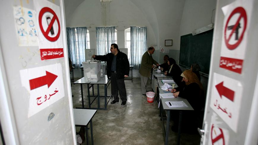 Palestinians cast their vote at a polling station in the West Bank town of Jenin, January 25, 2006. Palestinians voted in their first parliamentary elections in a decade on Wednesday, a ballot that could bring the militant Islamic Hamas movement into government for the first time. REUTERS/Ammar Awad - RTR18X2V