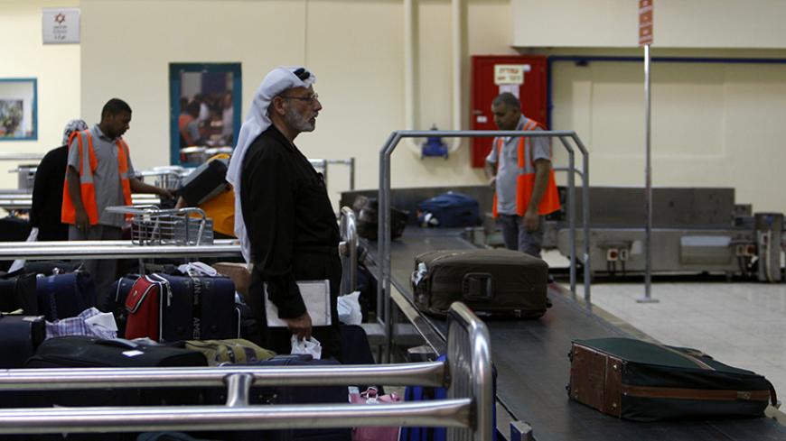 A traveller waits for his luggage at the Allenby Bridge Crossing July 9, 2009. Israel said on Wednesday it would allow the crossing between the occupied West Bank and Jordan to remain open 24 hours a day to help the Palestinian economy. The Israeli-controlled terminal leading to the Allenby Bridge across the Jordan River is the West Bank's only land link to the Arab world. REUTERS/Ammar Awad (WEST BANK POLITICS) - RTR25HFS