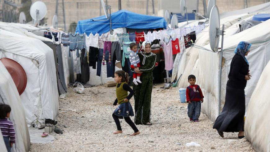 Syrian refugee women stand outside their tents at a refugee camp in Nizip in Gaziantep province, near the Turkish-Syrian border March 17, 2014. Aleppo continues to bear the brunt of the civil war, in which about 140,000 people have died. Almost two years after rebels grabbed half of the city, they are now on the defensive, with government forces advancing on three sides. Turkey began building its refugee camps near the border in mid-2011, little knowing the war would last so long and bring such vast numbers