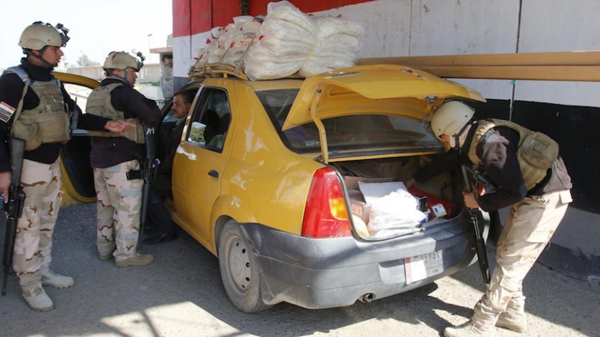 Iraqi security forces check the trunk of a vehicle at a checkpoint, as security measures increase in the west of Baghdad, February 29, 2016.  REUTERS/Khalid al Mousily - RTS8KWW