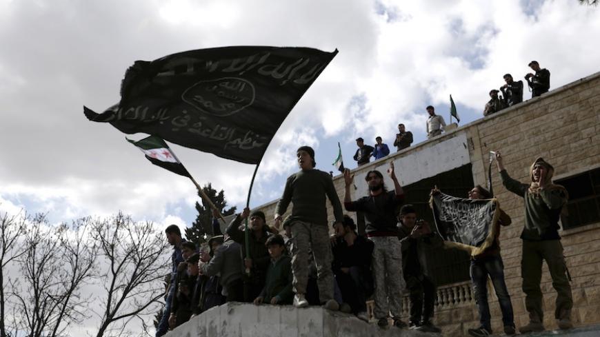 Protesters carry Al-Qaeda flags during an anti-government protest after Friday prayers in the town of Marat Numan in Idlib province, Syria, March 11, 2016. REUTERS/Khalil Ashawi - RTSAD3X