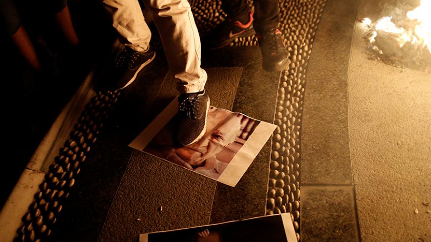 A supporter of Turkish President Tayyip Erdogan steps on a photo of U.S.-based cleric Fethullah Gulen during a pro-government demonstration on Taksim Square in Istanbul, Turkey, July 18, 2016. REUTERS/Alkis Konstantinidis - RTSILD2