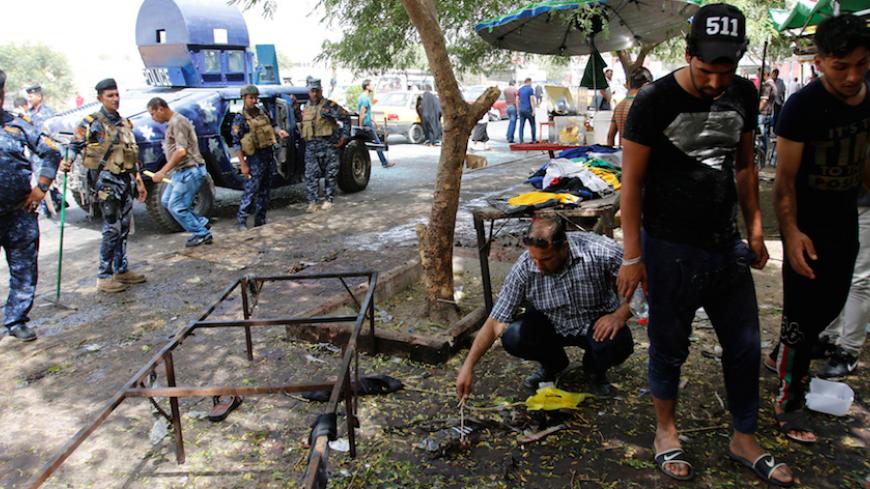 Residents and Iraqi security forces inspect the site where a suicide bomber detonated his explosive vest at the entrance to Kadhimiya, a mostly Shi'ite Muslim district in northwest Baghdad, Iraq July 24, 2016. REUTERS/Khalid al Mousily - RTSJDJ7