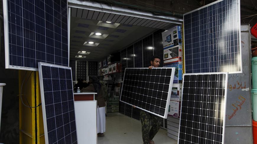 A man carries a solar panel amid a severe shortage of electric power in Yemen's capital Sanaa November 28, 2015. REUTERS/Mohamed al-Sayaghi - RTX1W96L
