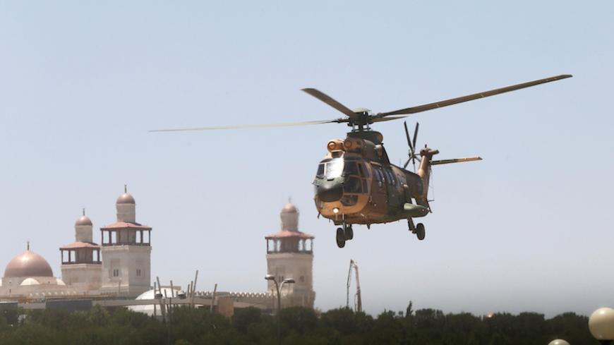 A military helicopter transports a security member, who was injured during an attack at a camp for Syrian refugees in eastern Jordan near the borders of Iraq, Syria and Jordan, to al-Hussein Medical Centre in Amman, Jordan, June 21, 2016.  REUTERS/Stringer - RTX2HCNT