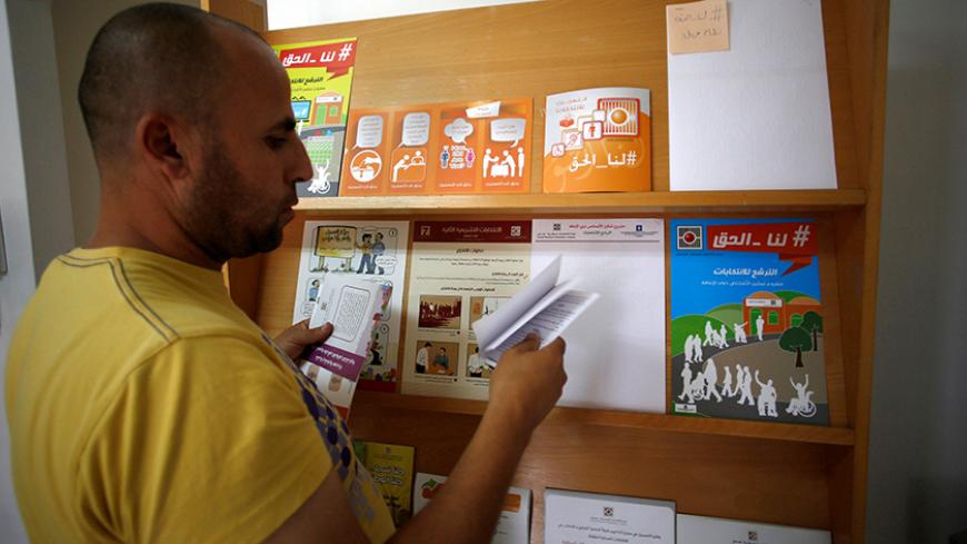 A Palestinian man check voting pamphlets in the office of the Central Elections Commission in the West Bank town of El Bireh August 17, 2016. REUTERS/Mohamad Torokman  - RTX2LI45