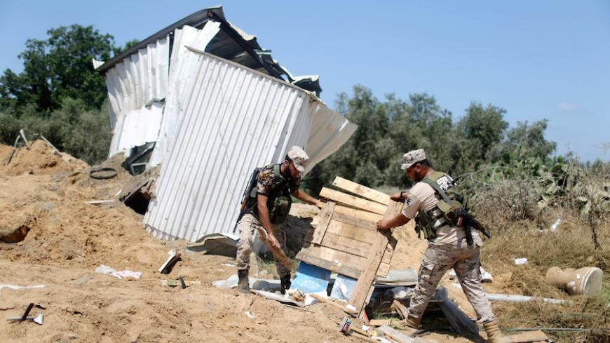 Members of Palestinian security forces loyal to Hamas survey a Hamas site after it was hit by an Israeli air strike in the northern Gaza Strip August 22, 2016. REUTERS/Ibraheem Abu Mustafa  - RTX2MINM