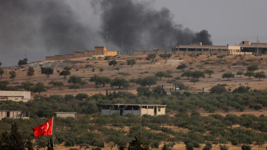Smoke rises from the Syrian border town of Jarablus as it is pictured from the Turkish town of Karkamis, in the southeastern Gaziantep province, Turkey, August 24, 2016. REUTERS/Umit Bektas - RTX2MVAL