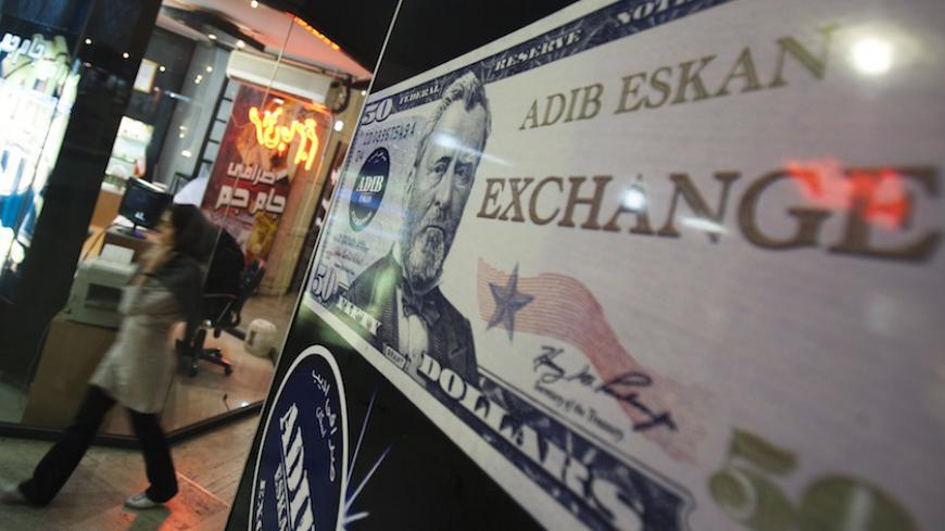 EDITORS' NOTE: Reuters and other foreign media are subject to Iranian restrictions on their ability to report, film or take pictures in Tehran.

A woman walks past a currency exchange shop at a shopping centre in northern Tehran October 3, 2010. Iran's currency, the rial, defied central bank attempts to revive its value on Sunday, remaining weak after falling 13 percent against the dollar last week. Morteza Nikoubazl (IRAN - Tags: BUSINESS POLITICS) - RTXSZAF