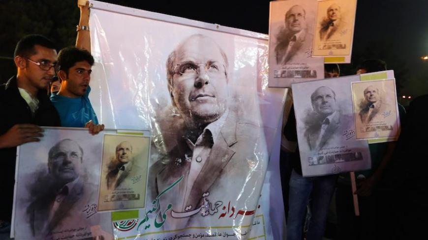 Supporters of Iranian presidential candidate Tehran's mayor Mohammad Bagher Ghalibaf hold a banner depicting him, in Shahr-e-Rey, south of Tehran, on June 7, 2013. Candidates vying for Iran's presidency clashed on June 7 in a heated televised exchange over nuclear talks with world powers, with pointed criticism aimed at top nuclear negotiator and hardline candidate Saeed Jalili. AFP PHOTO / ATTA KENARE        (Photo credit should read ATTA KENARE/AFP/Getty Images)