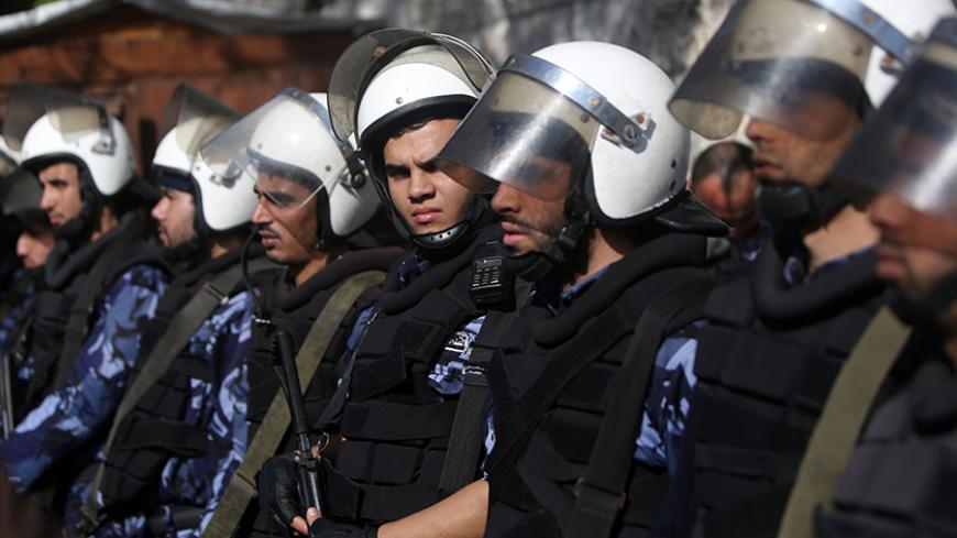 Hamas security forces stand guard at the entrance of the cabinet headquarters of Gaza's Hamas rulers on December 30, 2014 in Gaza City before a meeting of Palestinian unity government officials to launch reconstruction of the territory devastated by a 50-day summer war with Israel. Speaking late on December 29 shortly after a ministerial delegation from the West Bank arrived in Gaza, former Hamas prime minister Ismail Haniya accused the government of failing "to keep its commitments, by not carrying out rec