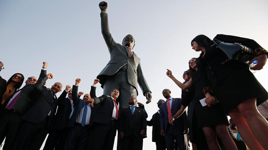 Palestinian and South African officials pose in front of a giant statue of Nelson Mandela during its inauguration ceremony in the West Bank city of Ramallah on April 26, 2016.
Palestinians inaugurated the statue of Mandela donated by the South African city of Johannesburg to their political capital. The six-metre (20-foot) two-tonne bronze statue was a gift from Johannesburg with which Ramallah is twinned.
/ AFP / ABBAS MOMANI (Photo credit should read ABBAS MOMANI/AFP/Getty Images)