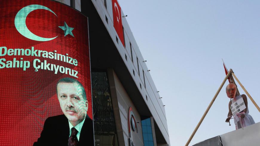 A picture taken on August 2, 2016 shows  a picture of Turkish President Recep Tayyip Erdogan (L) on a billboard and a mask bearing a picture of US-based preacher Fethullah Gulen set up on a dummy at the Kizilay Square in Ankara during a protest against the failed military coup, on August 2, 2016. 
Erdogan said on August 2, 2016 last month's attempted coup was a scenario drawn up from outside Turkey, in an allusion to possible foreign involvement in the plot. Erdogan, who blames the plot on the US-based prea
