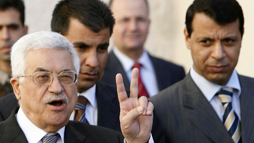 Palestinian President Mahmoud Abbas (L) gestures as Fatah strongman and lawmaker Mohammed Dahlan looks on (R) after meeting with British Prime Minister Tony Blair at the Palestinian Authority headquarters in the West Bank city of Ramallah December 18, 2006. Abbas told Blair on Monday he would push on with plans for early elections despite bitter opposition from the Hamas government. Blair said it was critical that the international community supported the moderate Abbas in the coming weeks. REUTERS/Eliana A