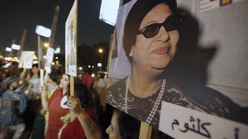 Egyptian women carry a picture of late Egyptian singer Oum Kalthoum during a protest supporting women's rights in the constitution and protesting against harassment against women and child marriage, in front of the presidential palace in Cairo October 4, 2012. REUTERS/Amr Abdallah Dalsh (EGYPT - Tags: POLITICS CIVIL UNREST) - RTR38T58