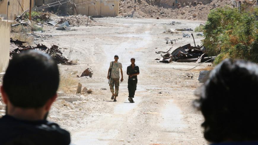 Rebel fighters walk by damaged buildings near Castello road in Aleppo, Syria September 16, 2016. REUTERS/Abdalrhman Ismail - RTSO1TA