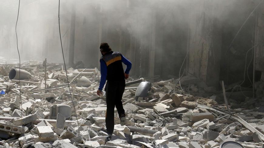 A man walks on the rubble of damaged buildings after an airstrike on the rebel held al-Qaterji neighbourhood of Aleppo, Syria September 25, 2016. REUTERS/Abdalrhman Ismail  - RTSPC0J