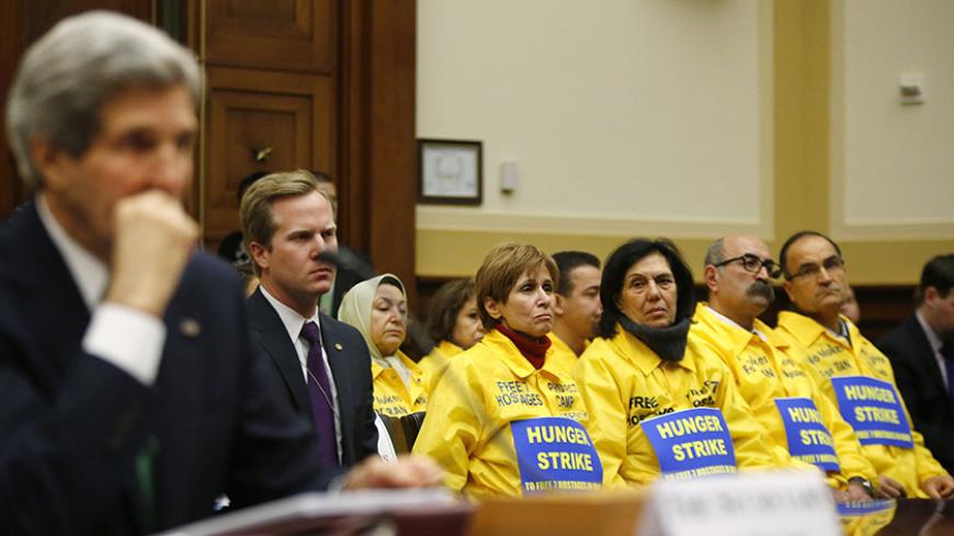 The U.S. families of Iranian dissidents, members of Iran's opposition movement Mujahedin-e Khalq (MEK) who reside in Camp Liberty in Iraq, look on as U.S. Secretary of State John Kerry testifies on agreements over Iran's nuclear programs, before the House Foreign Affairs Committee on Capitol Hill in Washington, December 10, 2013. REUTERS/Jonathan Ernst (UNITED STATES - Tags: POLITICS MILITARY) - RTX16CNF