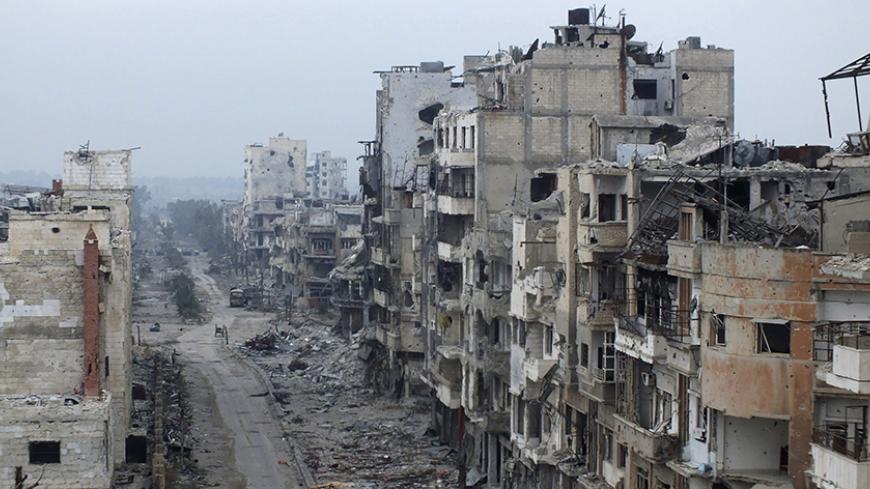 Damaged buildings line a street in the besieged area of Homs January 27, 2014. The United States on Monday demanded that Syria allow aid into the "starving" city of Homs, as talks aimed at ending three years of civil war hit more trouble over the future of President Bashar al-Assad. The Syrian government said women and children could leave the besieged city and that rebels should hand over the names of the men who would remain. A U.S. State Department spokesman said an evacuation was not an alternative to i