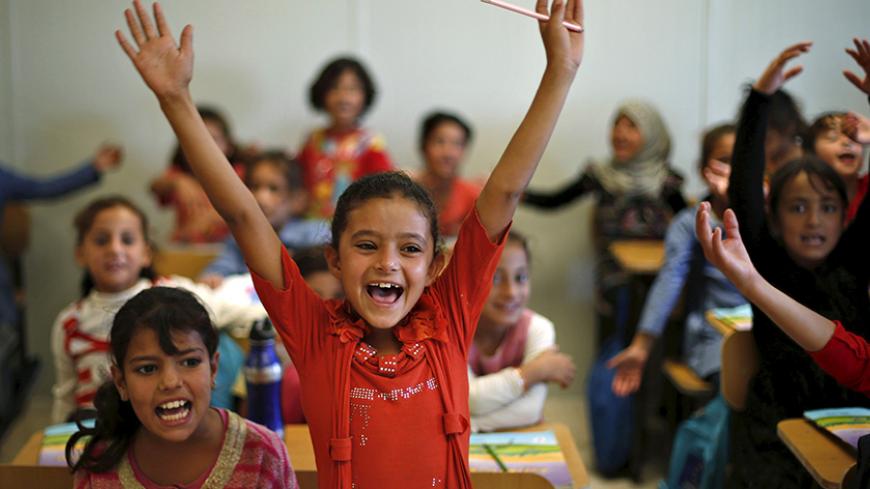 Syrian refugee students gesture while attending a class in a UNICEF school, during German Economy Minister Sigmar Gabriel's visit to Al Zaatari refugee camp in the Jordanian city of Mafraq, near the border with Syria, September 22, 2015. REUTERS/ Muhammad Hamed      TPX IMAGES OF THE DAY      - RTX1RVB9