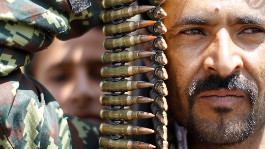 An armed man loyal to the Houthi movement holds up ammunition as he gathers to protest against the Saudi-backed exiled government deciding to cut off the Yemeni central bank from the outside world, in the capital Sanaa, Yemen August 25, 2016. REUTERS/Mohamed al-Sayaghi - RTX2N19E