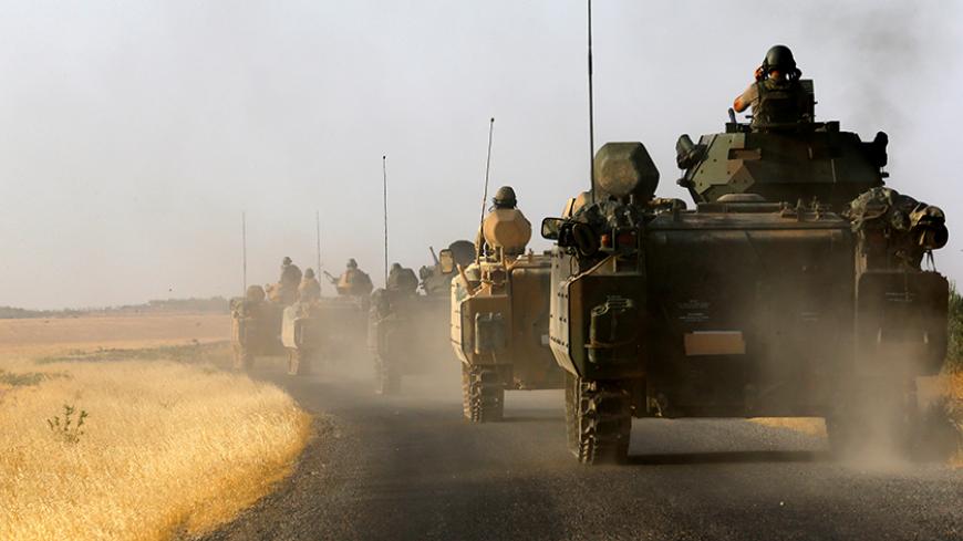 Turkish armoured personnel carriers drive towards the border in Karkamis on the Turkish-Syrian border in the southeastern Gaziantep province, Turkey, August 27, 2016. REUTERS/Umit Bektas  - RTX2N8HX