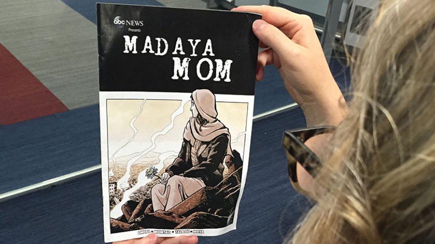 In this setup photo a woman looks at the cover of the comic book "Madaya Mom" in Washington, DC on October 7, 2016.
The book, titled "Madaya Mom," is available online for free on the ABC News website. ABC News has been in contact with a woman from the syrian town of Madaya, near the lebanese border. Madaya has been held under siege by the syrian regim army for the better part of the last two years. The woman, who's a mother of five, has sent messages to describe her everyday life. These messages were used a