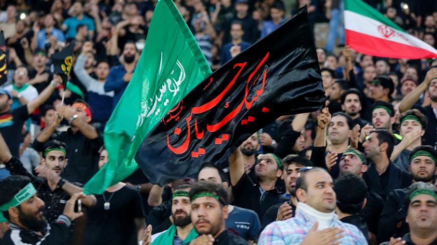Iranian fans wave a religious banner to mark Ashura, which marks the death of Prophet Mohammed's grandson Imam Hussein in the seventh century, during the 2018 World Cup qualifying football match between Iran and South Korea at the Azadi Stadium in Tehran on October 11, 2016. / AFP / ATTA KENARE (Photo credit should read ATTA KENARE/AFP/Getty Images)