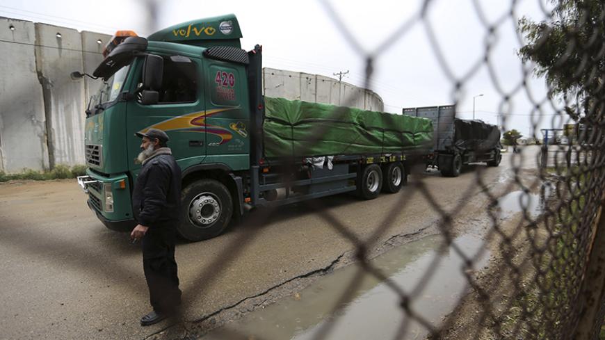A Palestinian policeman stands guard as a truck loaded with fruits and vegetables waits to cross into the Israeli side of the Kerem Shalom crossing in Rafah in the southern Gaza Strip March 12, 2015. Israel imported its first fruit and vegetables from the Gaza Strip in almost eight years on Thursday, in a partial easing of an economic blockade maintained since the Islamist group Hamas seized control of the Palestinian territory. Twenty-seven tonnes of tomatoes and five tonnes of eggplants were trucked acro