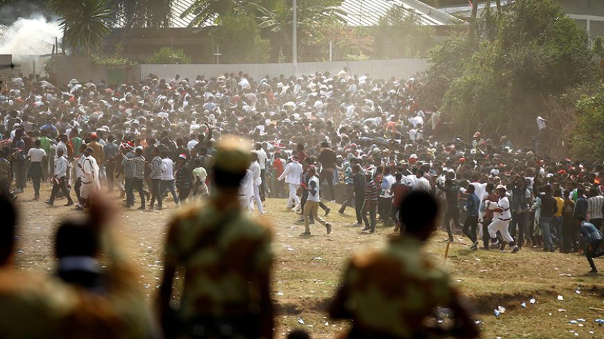 Protestors run from tear gas launched by security personnel during the Irecha, the thanks giving festival of the Oromo people in Bishoftu town of Oromia region, Ethiopia, October 2, 2016. REUTERS/Tiksa Negeri     TPX IMAGES OF THE DAY - RTSQFPV