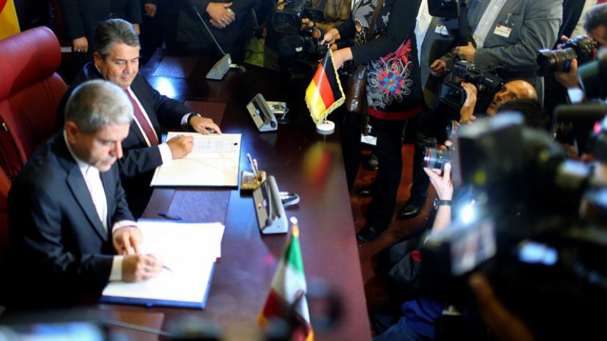 German Economy Minister Sigmar Gabriel and Iranian economy minister Ali Tayebnia sign contracts during a conference in Tehran, Iran October 3, 2016. REUTERS/Hannibal Hanschke - RTSQIGL