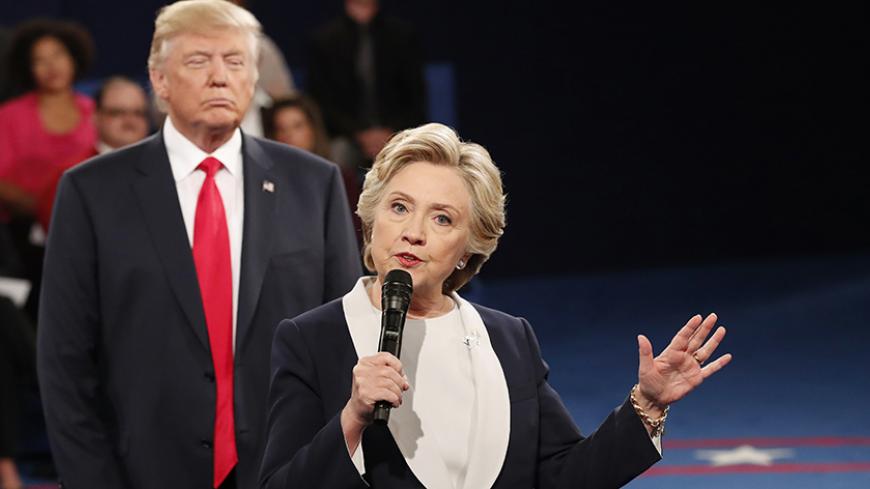 Republican U.S. presidential nominee Donald Trump listnes as Democratic nominee Hillary Clinton answers a question from the audience during their presidential town hall debate at Washington University in St. Louis, Missouri, U.S., October 9, 2016. REUTERS/Rick Wilking - RTSRITA
