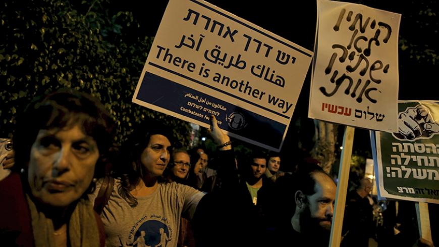 Israeli left wing demonstrators march holding placards protesting the right wing incitement against President Reuven Rivlin and human rights activists in Tel Aviv. December 19, 2015. An ultra-nationalist Israeli group has published a video accusing the heads of four of Israel's leading human rights organisations of being foreign agents funded by Europe and supporting Palestinians "involved in terrorism". The sign (C) reads, "The right will not silence me." REUTERS/Baz Ratner - RTX1ZETU
