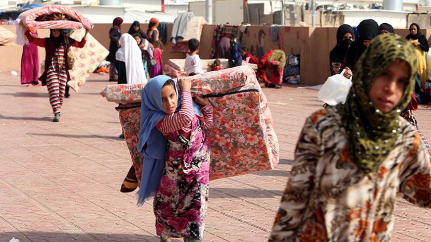 Displaced people who fled Islamic State militants from Mosul receive aid at Deepaka camp in the northwest of Erbil, during an operation to attack Islamic State militants in Mosul, Iraq, October 20, 2016. REUTERS/Alaa Al-Marjani  - RTX2PQDQ