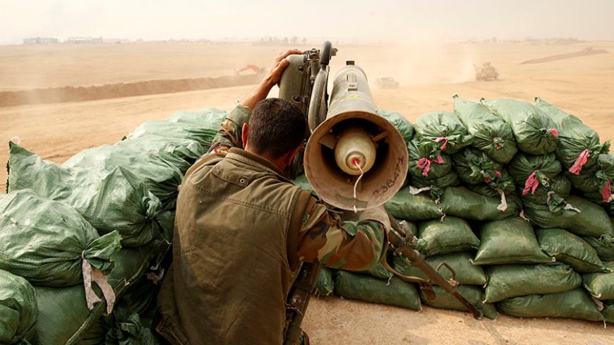 A Kurdish Peshmerga fighter with Milan anti tank weapon guards against possible Islamic State suicide bomb attacks during a battle with Islamic State militants at Topzawa village, near Bashiqa, near Mosul, Iraq October 24, 2016. REUTERS/Ahmed Jadallah - RTX2Q845