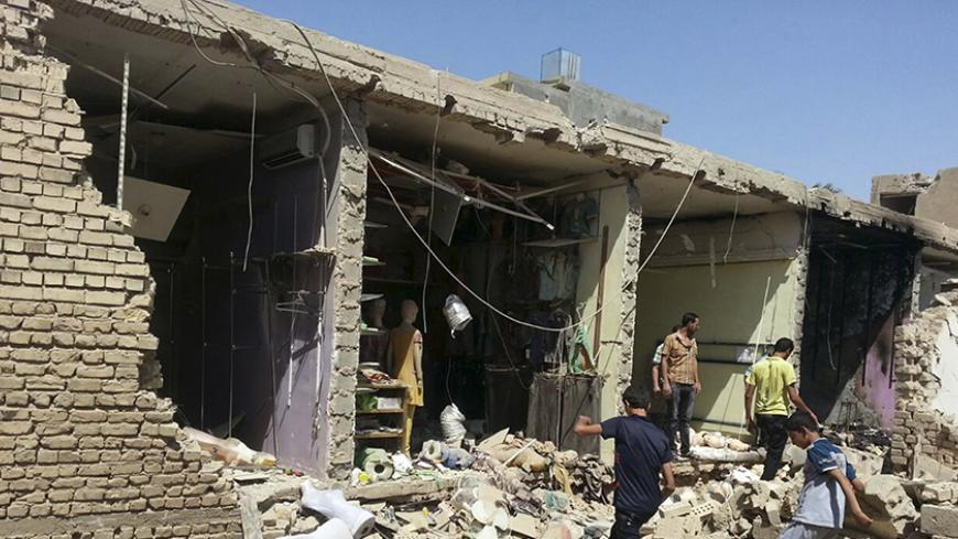 Residents inspect a market after a bomb attack in Fallujah, west of Baghdad, August 3, 2014. Picture taken August 3, 2014. REUTERS/Stringer (IRAQ - Tags: CIVIL UNREST POLITICS) - RTR414ZS