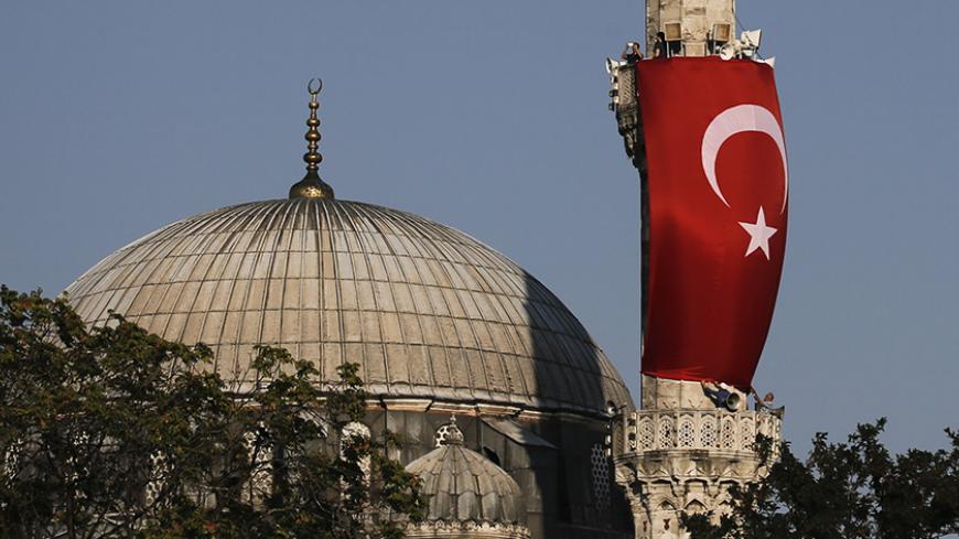 A Turkish flag is seen next to the dome of a mosque in Istanbul, Turkey, July 16, 2016.    REUTERS/Alkis Konstantinidis - RTSIBCJ