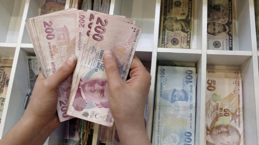 A money changer counts Turkish lira bills at an currency exchange office in central Istanbul, Turkey, August 21, 2015. REUTERS/Murad Sezer/File Photo - RTSKTP9