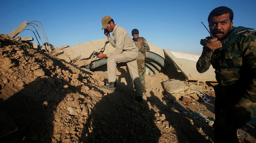 Members of the Shi'ite Badr Organisation fighters take cover behind a berm during a battle with Islamic State militants at the airport of Tal Afar west of Mosul, Iraq, November 20, 2016. REUTERS/Khalid al Mousily - RTSSJEJ