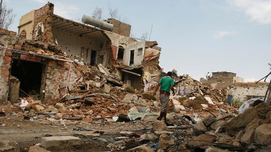 A man walks past a house destroyed during recent fighting between pro-government fighters and Houthi fighters in the southwestern city of Taiz, Yemen November 26, 2016. REUTERS/Anees Mahyoub - RTSTDZM