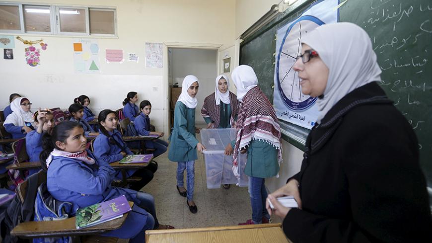 A teacher distributes meals to students as part of a World Food Programme (WFP)-run project to provide healthy meals to students and to raise awareness of good eating habits, at Hofa Al-Mazar school  in the city of Irbid, Jordan, April 26, 2016. REUTERS/ Muhammad Hamed - RTX2BQMO