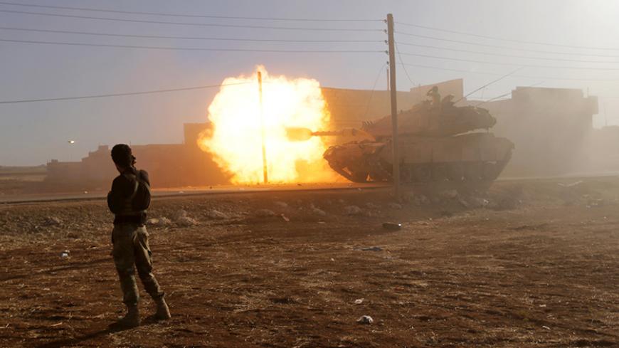 A rebel fighter stands near a Turkish tank as it fires towards Guzhe village, northern Aleppo countryside, Syria October 17, 2016. REUTERS/Khalil Ashawi       TPX IMAGES OF THE DAY      - RTX2P879